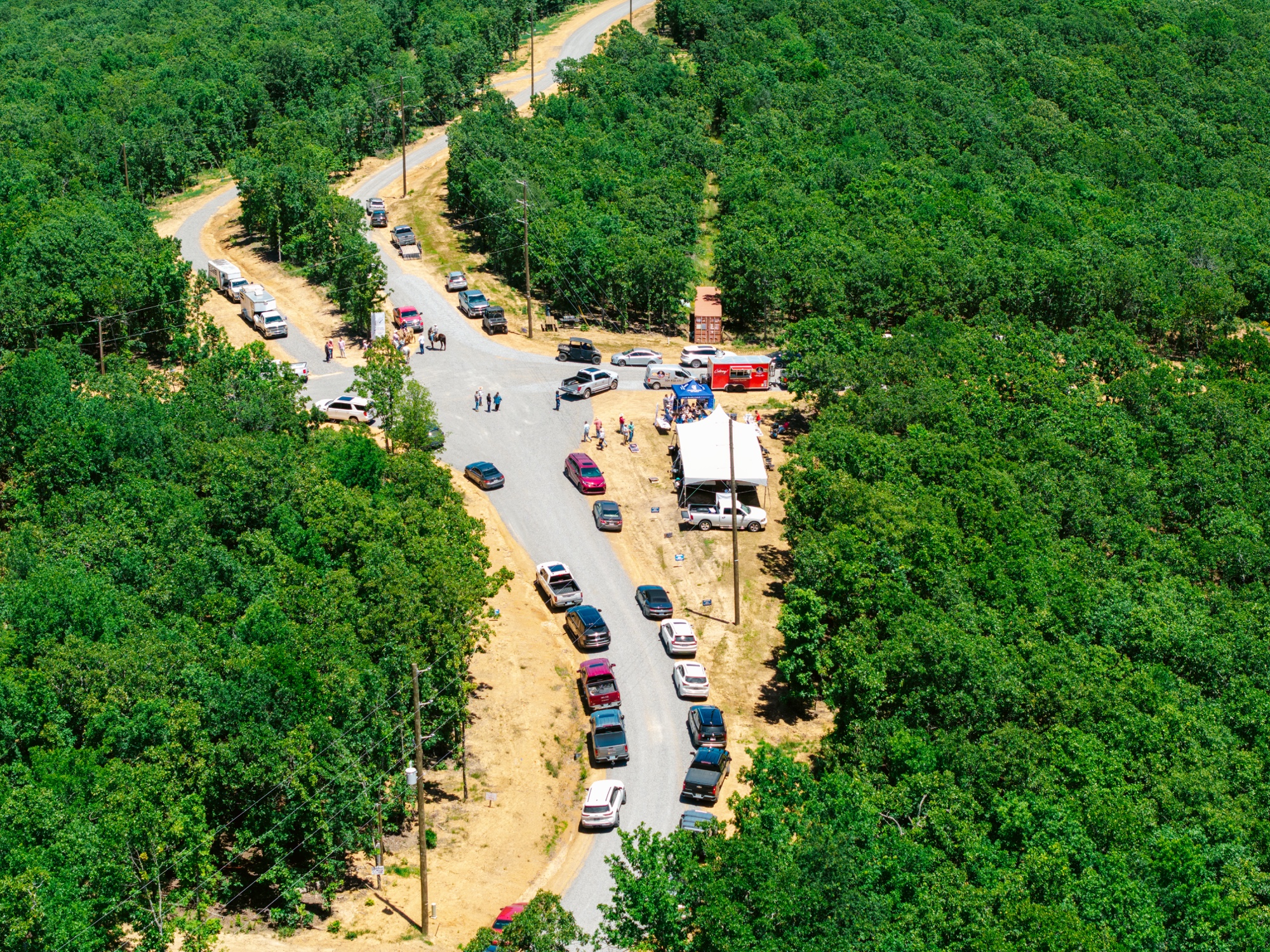 Drone aerial view of the 7 Lakes Ranch Estates development at grand opening with roads laid out and cars lined up